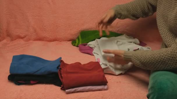 Primer plano de la mujer que pone hacia fuera lavada ropa y ropa de niño — Vídeo de stock