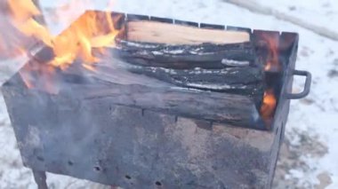 Yanan odun şöminesi Kışın siyah metal ateş çukurunda yanan ateş
