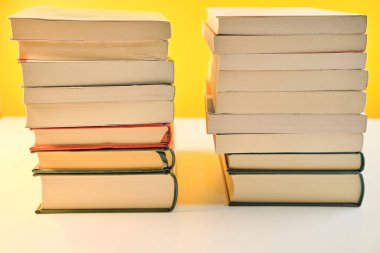 Kütüphane odasında sarı zemin üzerinde çeşitli kitap yığınları koleksiyonu
