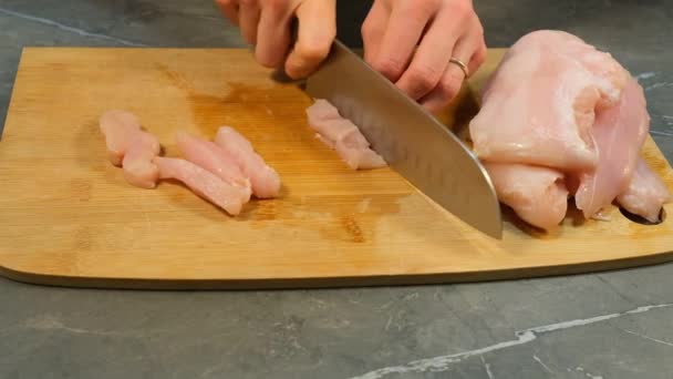 Felii de cuțit de pui Piept Filet de carne albă brută pe placa de tăiere din lemn — Videoclip de stoc