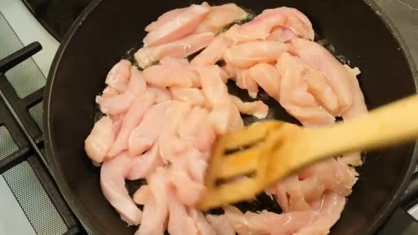 在平底锅里搅拌鸡胸肉，在厨房里煮鸡肉 — 图库视频影像