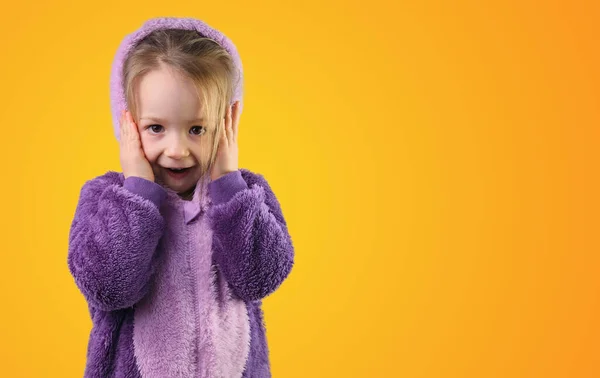 Mor pijamalı küçük çocuk şaşırdı. Ellerini başının üstüne koydu. 