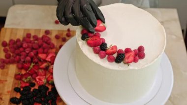 Pasta şefi kadın pasta yapıyor taze böğürtlen dönüşümlü masa. Yüksek kalite 4k görüntü