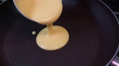 slow motion Pouring pancake mixture frying pan closeup American breakfast. High quality 4k footage