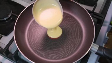 slow motion Pouring pancake mixture frying pan closeup American breakfast. High quality 4k footage