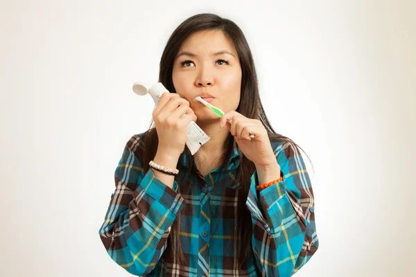 Dişlerini fırçalayan Asyalı kadın.