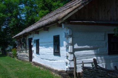 Yazın Ukrayna 'da bir köyde samandan yapılmış çatısı olan eski kırsal ahşap bir Slav kulübesi..
