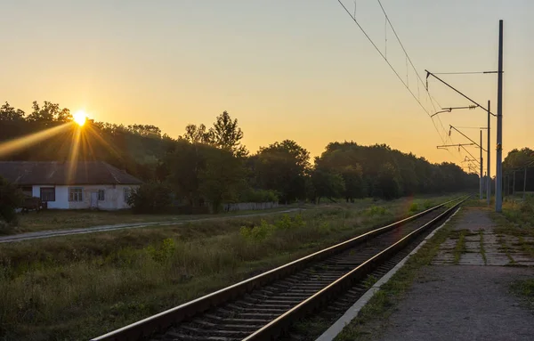 Ukrayna 'da sabah erken saatlerde, arka planda terk edilmiş bir eski ev ve ormanla birlikte eski bir tren istasyonu..