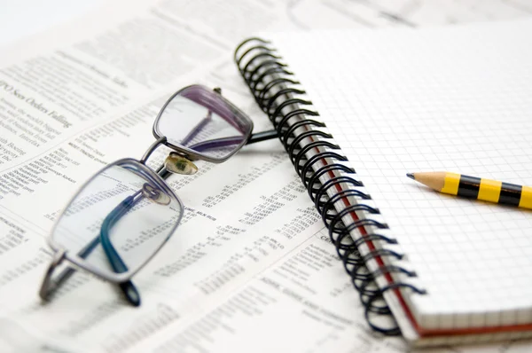 Wirtschaftstabelle, Zeitung, Block und Brille — Stockfoto