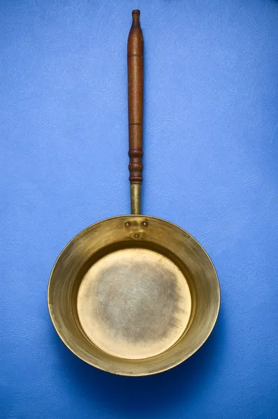 Vieille casserole en cuivre sur fond bleu — Photo