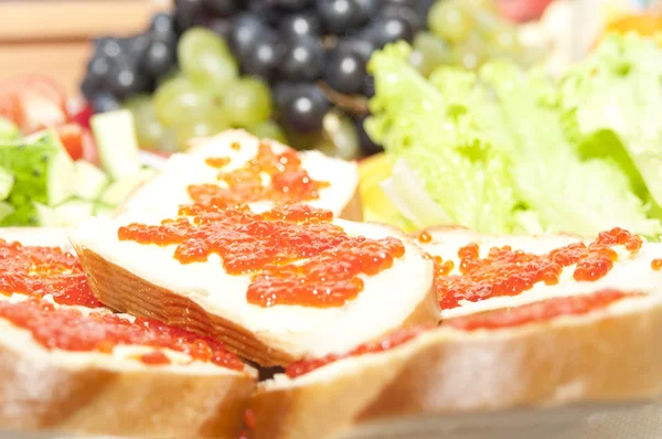 Sandwiches with caviar, salad and grape — Stock Photo, Image