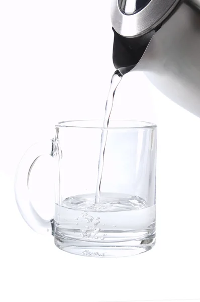 Наливание воды из чайника — стоковое фото