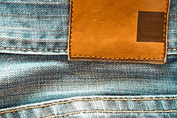 Old jeans with blank label — Stock Photo, Image