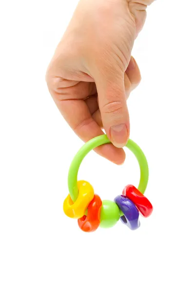 Rattle in hand on white background — Stock Photo, Image