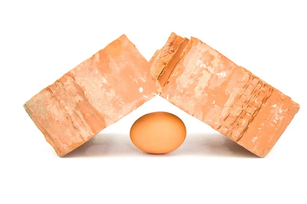 Bräckliga ägg bryter brutala tegel — Stock fotografie