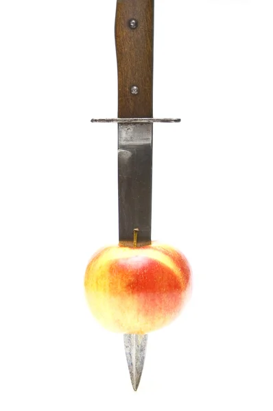 Dagger cutting an apple — Stock Photo, Image
