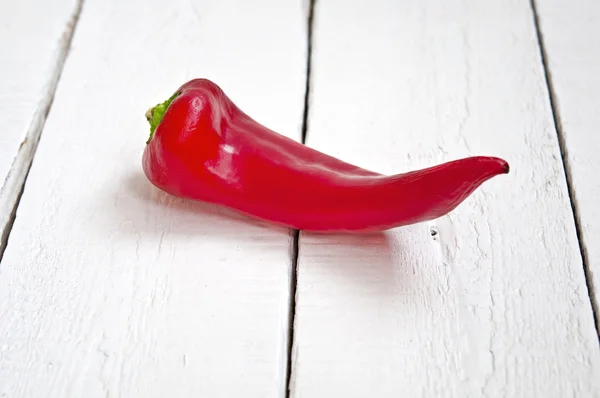 Červená paprika na dřevěném stole — Stock fotografie
