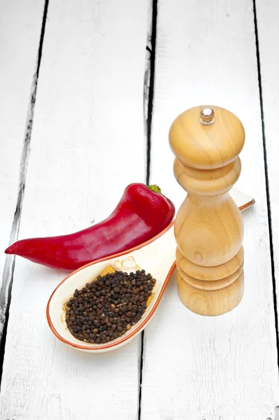 Paprika en peper schudbeker op houten tafel — Stockfoto