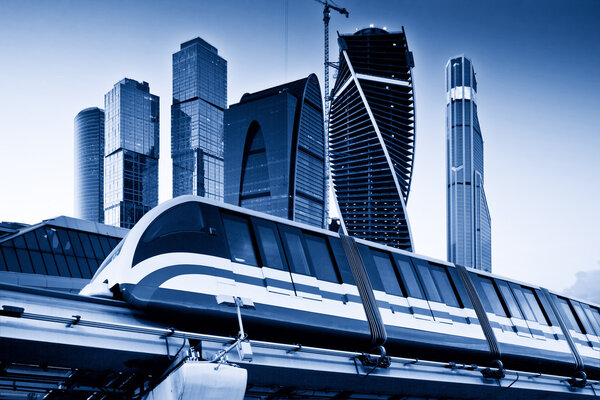 Skyscrapers and monorail train. Blue toned image