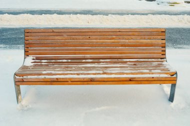 Empty wooden bench in a winter park