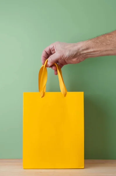 Man Hand Holding Yellow Shopping Bag Close — Stockfoto