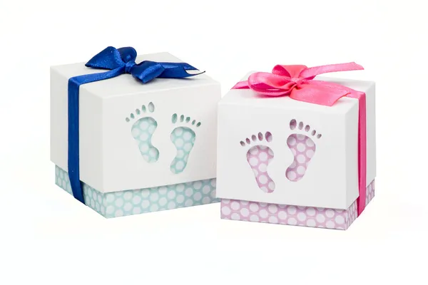 Две маленькие коробочки с подарком для новорожденного ребенка, розовые и голубые точки польки, сверху украшены луком — стоковое фото
