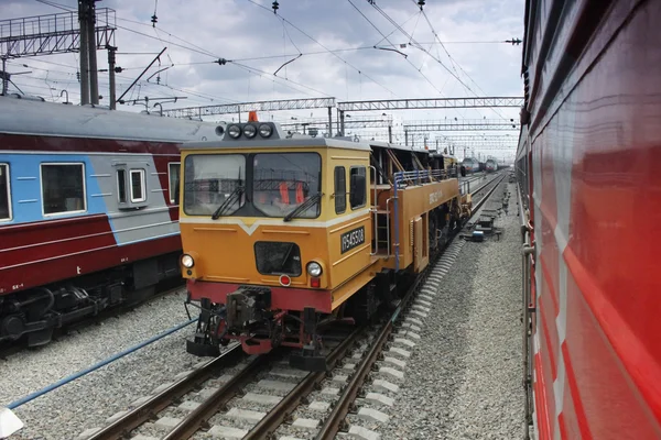 Locomotive on railway tracks between passenger trains — Stock Photo, Image