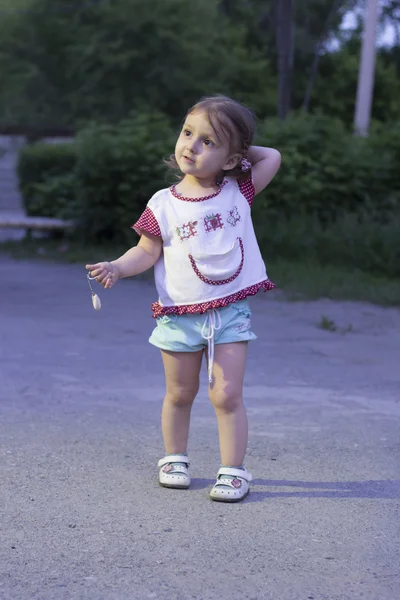 Malá holčička se ztratila. Dítě zůstalo v noci osamotě na ulici v parku a uvažilo, kudy jít — Stock fotografie