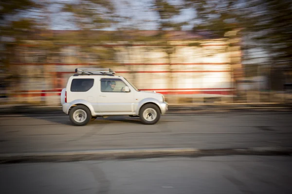 Russie - 1er avril 2013 : La voiture roule vite. SUV blanc à grande vitesse sur la route dans la ville — Photo