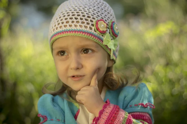 Niña pensó un dedo sobre su cara - Chica en punto cárdigan — Foto de Stock