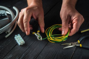 Elektrikçi ustasının atölyesindeki elektrikli aletlerin tamiri. İş sırasında ustanın ellerine yakın çekim. Ücretsiz reklam alanı.