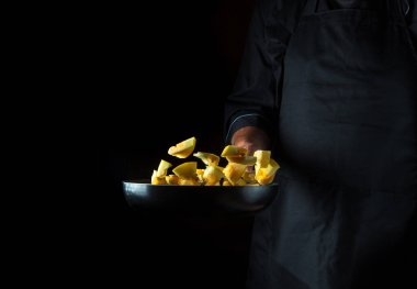 Aşçı kabağı tavada hazırlar. Sebze pişirmek sağlıklı vejetaryen yemeği ve yemeği karanlık bir arka planda pişirmek. Ücretsiz reklam alanı.