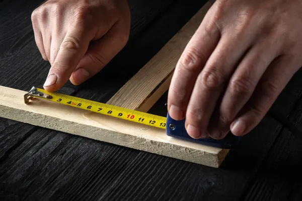 Stolarz Lub Stolarz Używa Taśmy Konstrukcyjnej Pomiaru Długości Kawałka Drewna — Zdjęcie stockowe
