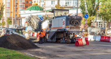 Yoldaki tamirat işi. İşçilere ve asfaltlama makinelerine yakından bakın: Kiev, Ukrayna - 07 Ekim 2021