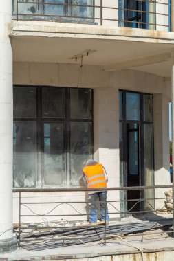 Eski bir binanın ön cephesinin restorasyonu ya da yenilenmesi. İşçi, konut inşaatı veya onarımı yapar.