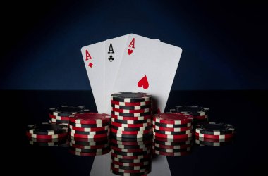 Üçlü ya da set kombinasyonlu poker oyunu. Fişler ve kartlar siyah masada. Başarılı ve üç as kazandı.