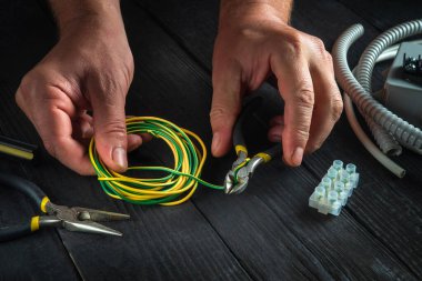 Elektrikçi ustasının atölyesinde elektrikli teçhizat denemesi ya da onarımı. İş sırasında ustanın ellerini yakın plan çek.