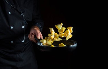 Profesyonel şef kabağı tavada pişirir. Sebze pişirmek sağlıklı vejetaryen yiyecekler ve karanlık arka planda yemek. Ücretsiz reklam alanı.