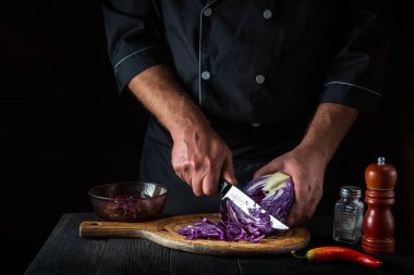Profesyonel bir şef kırmızı lahanayı bıçakla keser. Restoranın mutfağında sebze salatası pişiriyorum. Sebze diyeti fikri