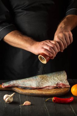 Aşçı ya da şef taze balık kocakafalı sazan balığı serpiştirir. Balık yemi pişirmeye hazırlanıyorum. Restoranda ya da kafe mutfağında çalışma ortamı