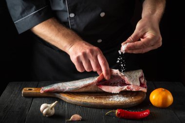 Profesyonel şef taze balık serpiştirir. Balık yemi pişirmeye hazırlanıyorum. Restoranın mutfağında çalışma ortamı