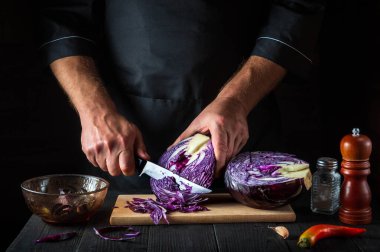 Profesyonel bir şef kırmızı lahanayı bıçakla keser. Restoranın mutfağında sebze salatası pişiriyorum. Sebze diyeti fikri