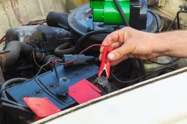 Eski araba aküsünü akü kablolarından elektrik kullanarak şarj et. Eski bir arabanın tamiri