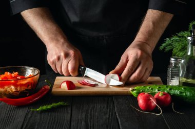 Şef ya da aşçı sebze salatasında turp keser. Restoranda ya da kafede lezzetli bir salata pişirmek.