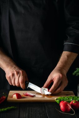 Şef sebze salatasında turp keser. Restoranda ya da kafede lezzetli bir salata pişirmek.