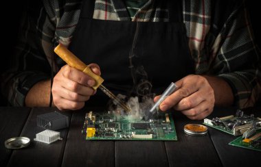 Bir atölyedeki ustabaşının bilgisayarları ya da elektronik aletleri tamir etmesi. Bir atölyede çalışan bir uzman tarafından bilgisayar onarım hizmeti