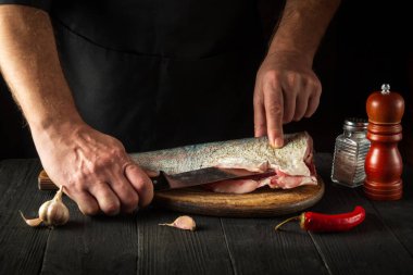 Aşçı pişirmeden önce balığı keser. Restoranın mutfağında çalışma ortamı. Balık diyeti konsepti