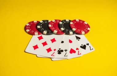 Poker oyunu, dörtlü ya da dörtlü kombinasyonlu. Fişler ve kartlar sarı masada. Başarılı ve dört yedili kazandı.