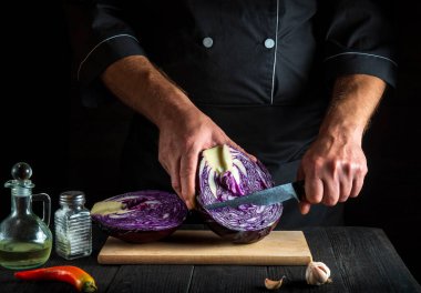 Profesyonel aşçı bıçakla kırmızı lahana kesiyor. Restoranın mutfağında sebze salatası pişiriyorum. Sebze diyeti fikri.