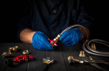 Profesyonel tesisatçı hortumu gaz musluğuna bağlıyor. Atölyeye gaz ekipmanı kurulumu.